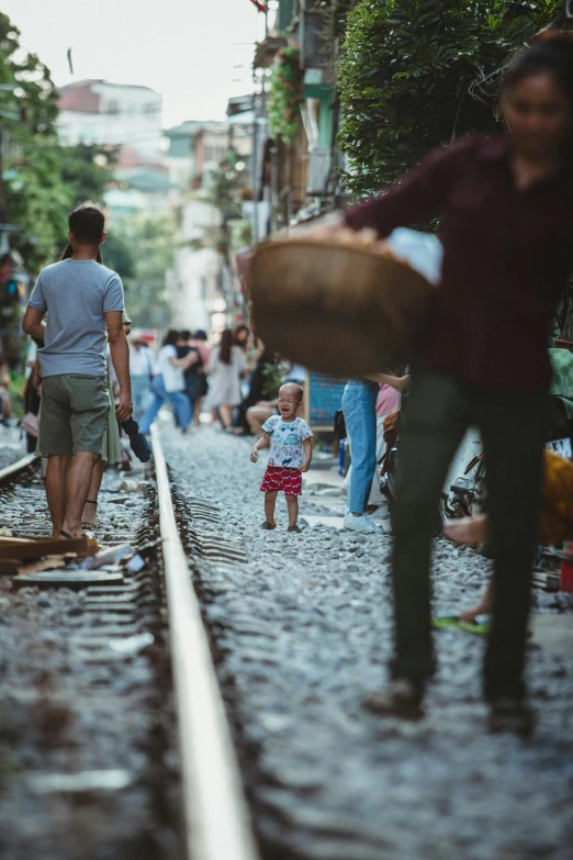 a group of people walking down a train track, pexels contest winner, happening, toddler, istanbul, square, vietnam