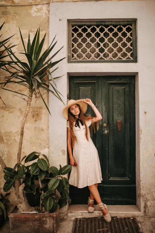 a woman standing in front of a green door, pexels contest winner, renaissance, wearing a white sundress, wearing a travel hat, cute girl, ::