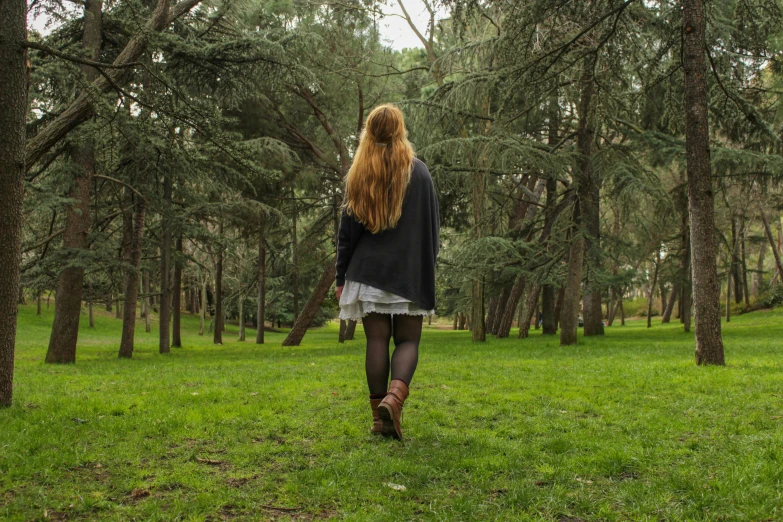 a woman walking through a lush green forest, an album cover, pexels contest winner, pre-raphaelitism, knee high socks, in a city park, arrendajo in avila pinewood, sadie sink