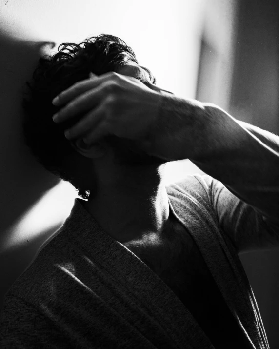 a black and white photo of a man holding his head, by Adam Marczyński, sunny light, heartbroken, daniel mirante, enes dirig