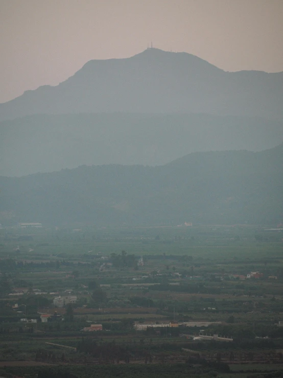 a plane that is flying in the sky, by Attila Meszlenyi, sumatraism, marbella landscape, very hazy, viewed from bellow, very sweaty