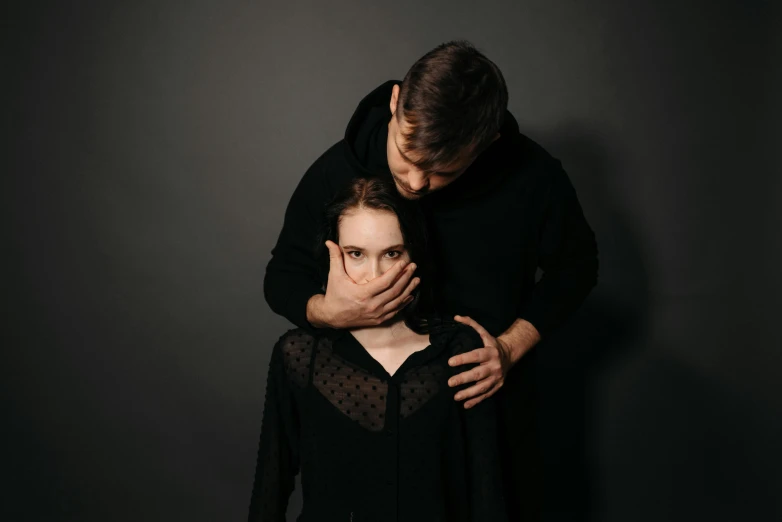 a man standing next to a woman in a black dress, pexels contest winner, antipodeans, she is frightened, studio shooting, 1 6 years old, holding each other