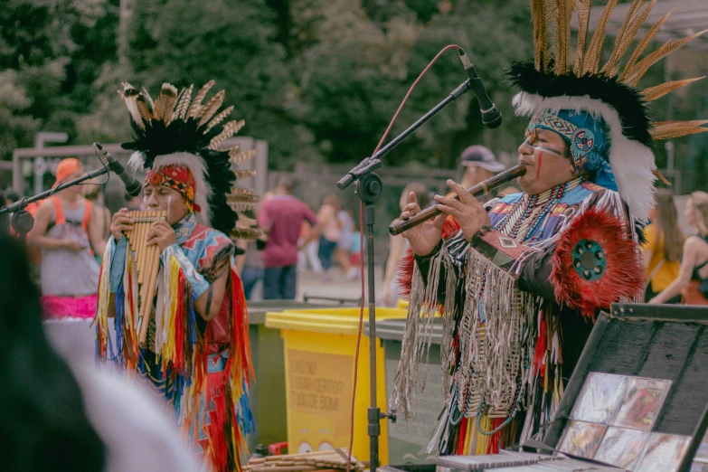 a couple of people that are standing in front of a microphone, tribal clothing, parade, unsplash photo contest winner, performing