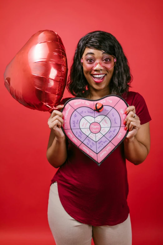 a woman holding a heart shaped balloon in front of her face, pexels contest winner, pop art, dart board, lizzo, female calendar, full product shot