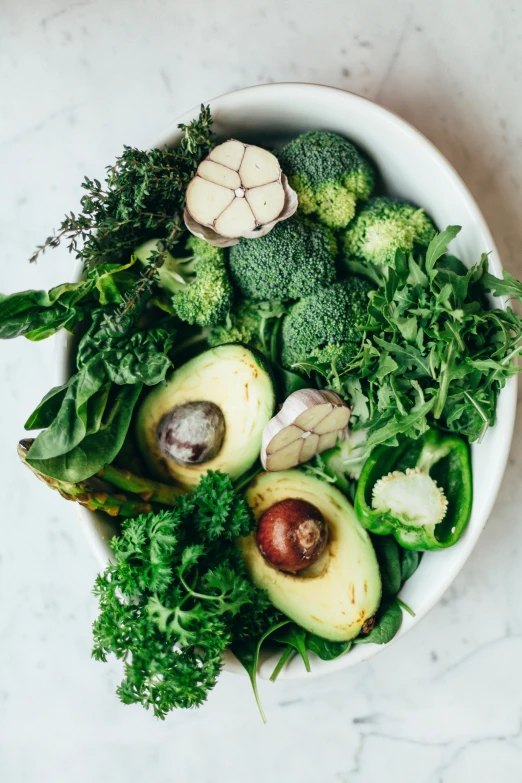 a white bowl filled with broccoli and other vegetables, a photo, pexels, avocados, lush greens, pure, grey