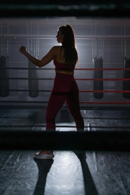 a woman standing in the middle of a boxing ring, pexels contest winner, arabesque, studio spotlight, facing away from camera, ( ( theatrical ) ), full body 8k