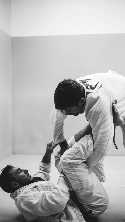 a couple of people that are in a room, a black and white photo, unsplash, white belt, air is being pushed around him, ariel perez, orange gi