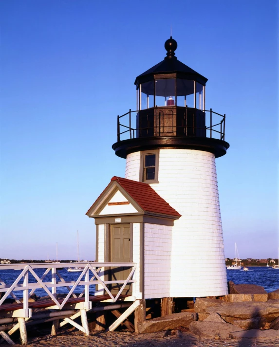 a white lighthouse sitting next to a body of water, square, lgbtq, 2006 photograph, set photo