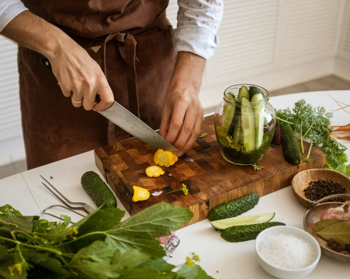 a person cutting vegetables on a cutting board, by Julia Pishtar, cucumbers, brown, fine dining, professionally assembled