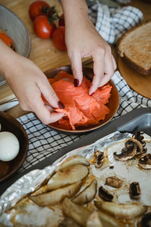 a close up of a plate of food on a table, cooking, hand holding a knife, eggs, salmon