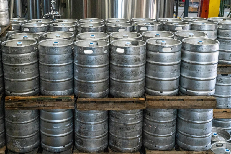 a bunch of metal kegs sitting on top of a wooden pallet, profile image, stainless steel, large jars on shelves, thumbnail