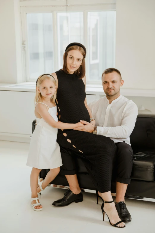 a woman sitting on a couch next to a man and a little girl, a picture, by Ivan Grohar, organic dress, on a white table, maternity feeling, 15081959 21121991 01012000 4k