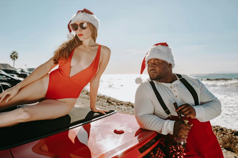 a woman sitting on top of a red car next to a man in a santa hat, pexels contest winner, renaissance, wearing two - piece swimsuit, huell babineaux, sam hyde, honey birdette