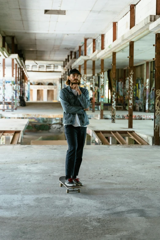 a man standing on a skateboard in a building, a portrait, unsplash contest winner, bearded and built, in an abandoned barn, profile image, full body length