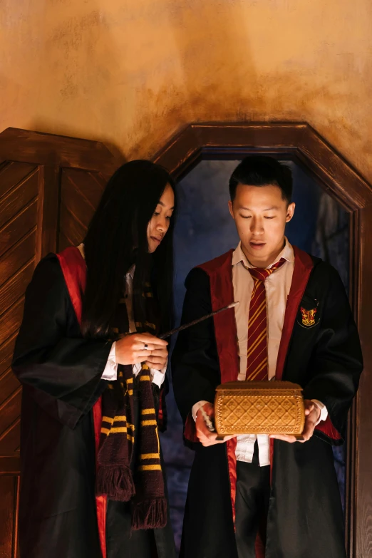 a couple of people standing next to each other, inspired by Fuller Potter, hogwarts gryffindor common room, looking at the treasure box, wearing headmistress uniform, hoang lap