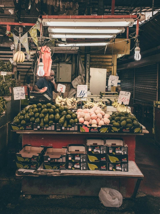 a man standing in front of a fruit stand, unsplash, happening, in chippendale sydney, during night, inside building, trending photo