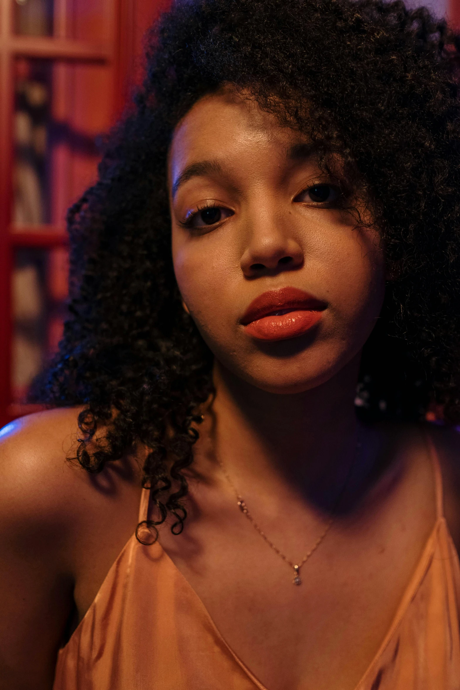 a close up of a person with a cell phone, an album cover, inspired by Nan Goldin, trending on pexels, renaissance, mixed-race woman, coral lipstick, confident pose, nighttime