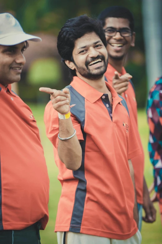 a group of men standing next to each other, by Max Dauthendey, pexels contest winner, happening, wearing polo shirt, wearing an orange t-shirt, with a happy expression, performance