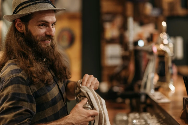 a man with long hair and a hat holding a rope, pexels contest winner, aussie baristas, at checkout, cider - man, thumbnail