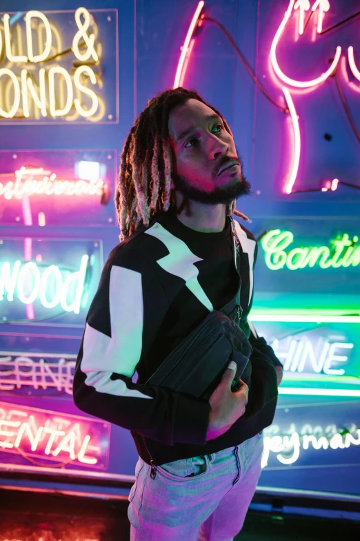 a man with dreadlocks standing in front of neon signs, trending on pexels, wearing a turtleneck and jacket, liam, reflective suit, waist high