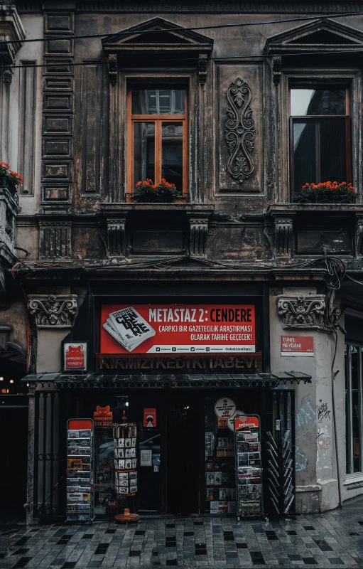 a tall building sitting on the side of a street, a poster, by Micha Klein, pexels contest winner, old shops, red banners, freddy mamani silvestre facade, turkish and russian