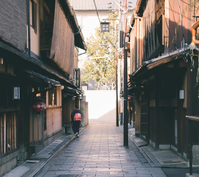 a person riding a skateboard down a narrow street, inspired by Tōshi Yoshida, unsplash contest winner, ukiyo-e, old buildings, natural morning light, 2 0 0 0's photo, street lanterns