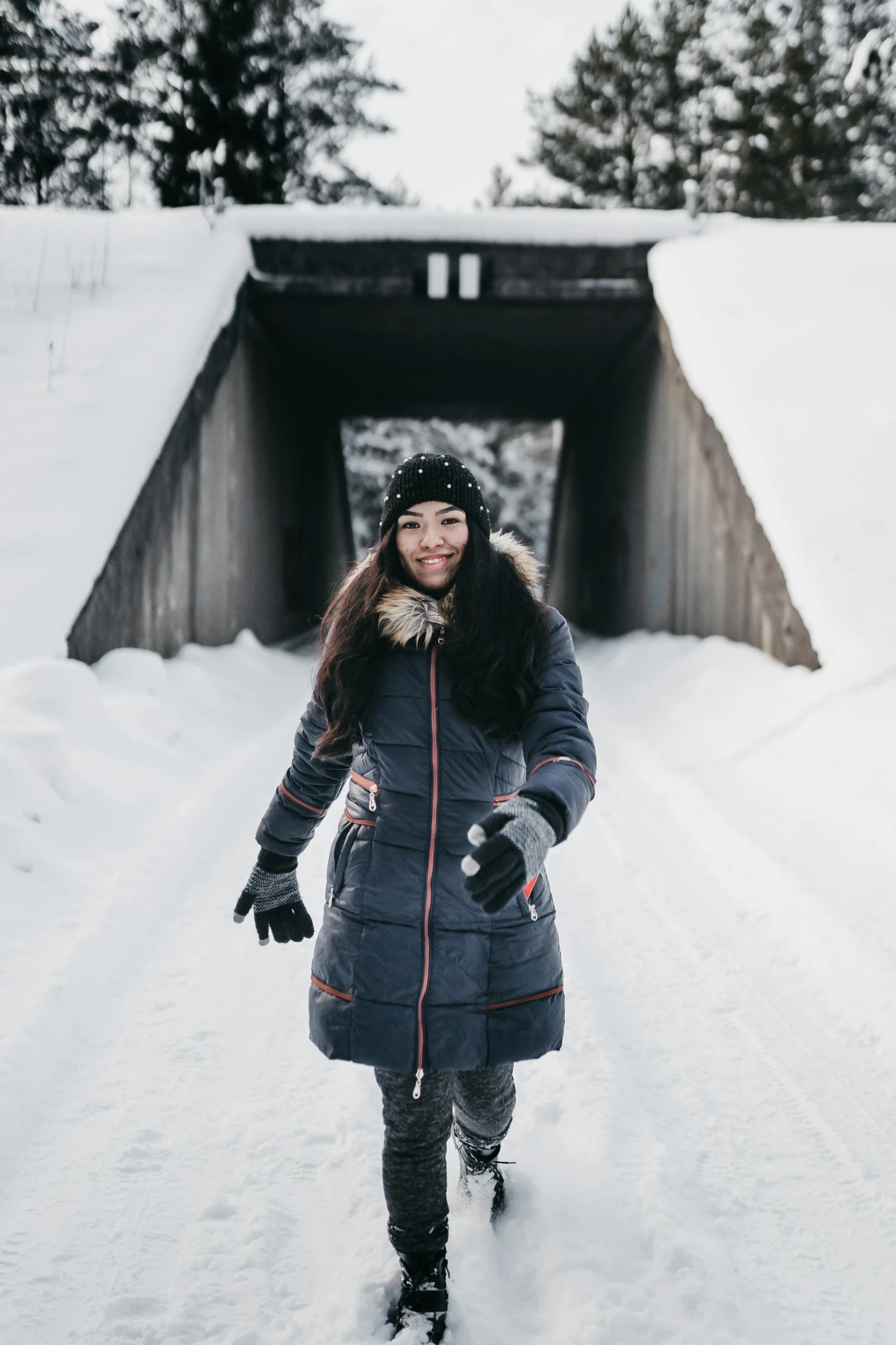 a woman standing in the snow in front of a tunnel, pexels contest winner, playful smirk, finland, in karuizawa, joanna gaines