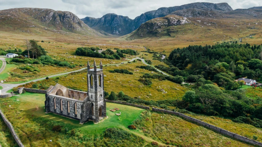 a church sitting on top of a lush green hillside, by Eamon Everall, pexels contest winner, aerial view of an ancient land, irish mountains background, conde nast traveler photo, smol