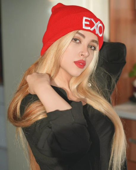a woman with long blonde hair wearing a red hat, an album cover, inspired by Elsa Bleda, trending on pexels, x logo, beanie hat, beautiful iranian woman, e-girl