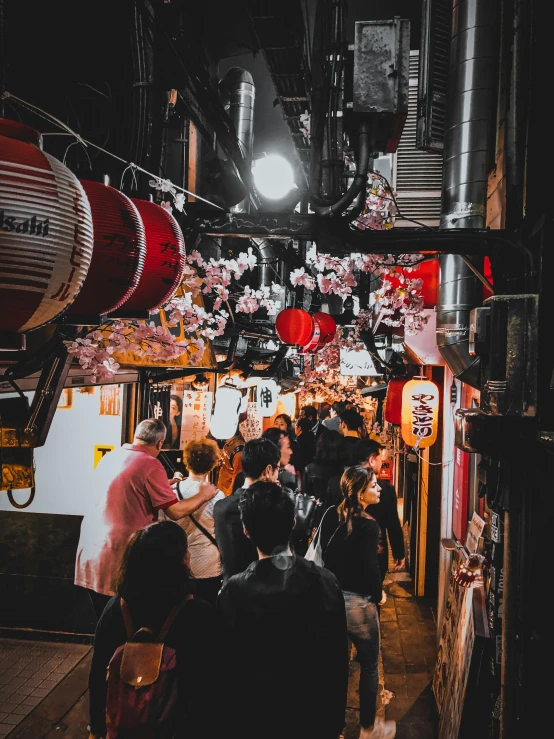 a group of people walking down a street at night, a photo, pexels contest winner, ukiyo-e, things hanging from ceiling, red white and black color scheme, drinking, 🌸 🌼 💮