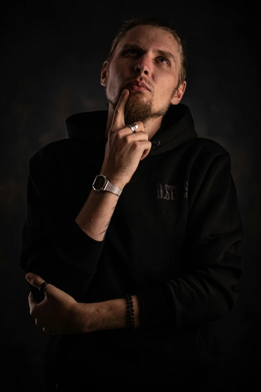 a man in a black hoodie smoking a cigarette, a character portrait, by Matthias Stom, trending on pexels, hyperrealism, posing with crossed arms, low quality photo, goatee, of portrait of justin beber