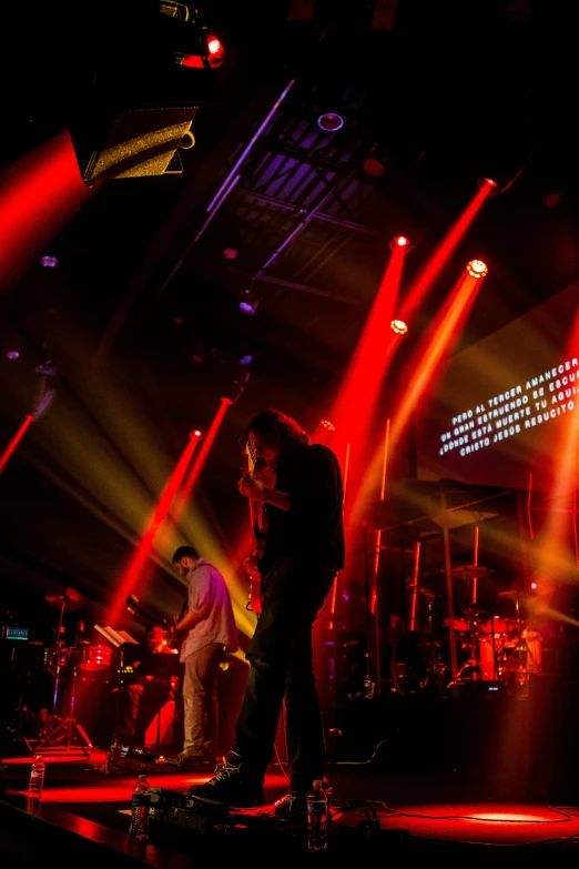 a group of people standing on top of a stage, by Robbie Trevino, bauhaus, orange and red lighting, worship, blur: -5