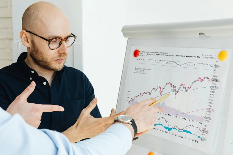 two men looking at a white board with graphs on it, by Adam Marczyński, trending on unsplash, with pointing finger, 🦩🪐🐞👩🏻🦳, healthcare, ultrarealistic