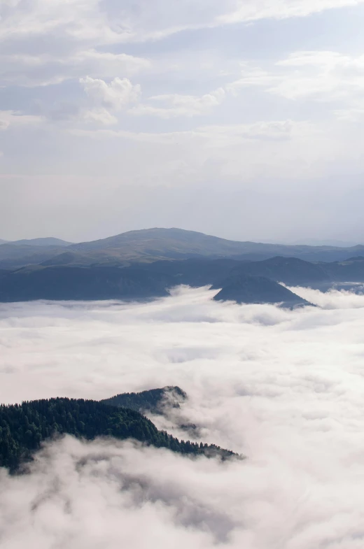 a group of people standing on top of a mountain, by Muggur, above low layered clouds, black forest, overview, zoomed in