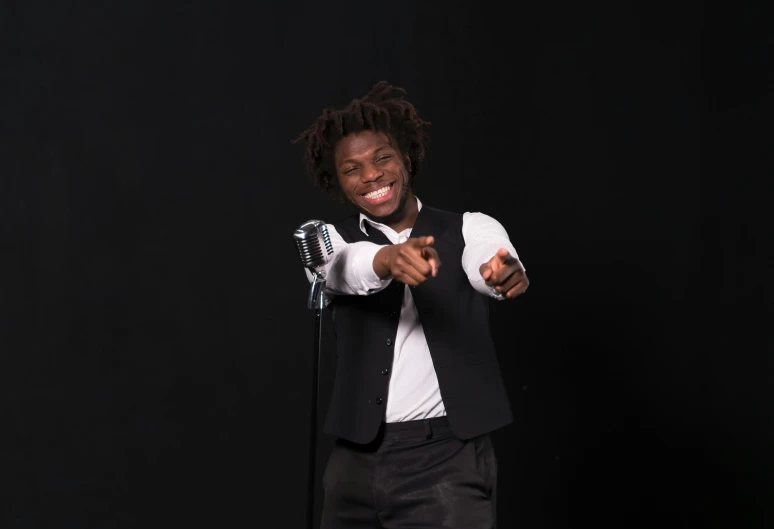 a man in a suit and tie holding a microphone, an album cover, inspired by Charles Martin, pexels contest winner, lyco art, casual pose, smileing nright, panel of black, lil uzi vert