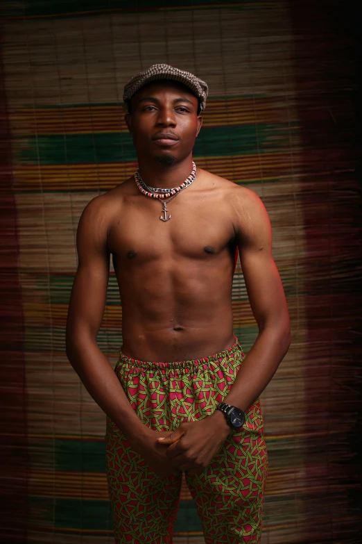 a shirtless man standing with his hands in his pockets, an album cover, inspired by Ras Akyem, renaissance, photographed for reuters, 18 years old, traditional dress, nas