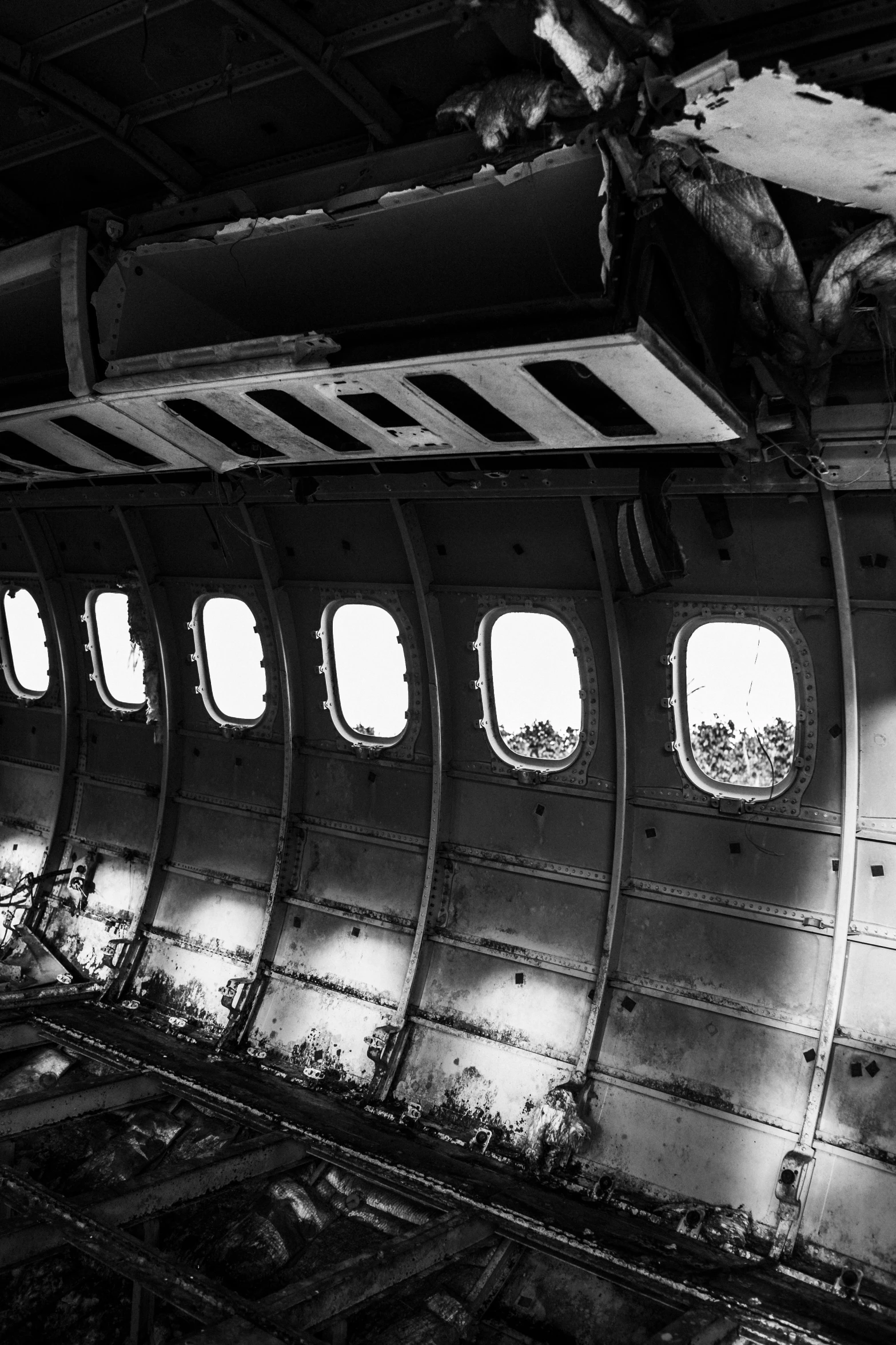 a black and white photo of the inside of an airplane, by Dave Melvin, unsplash, surrealism, ruined, 1990 photograph, panel, plain