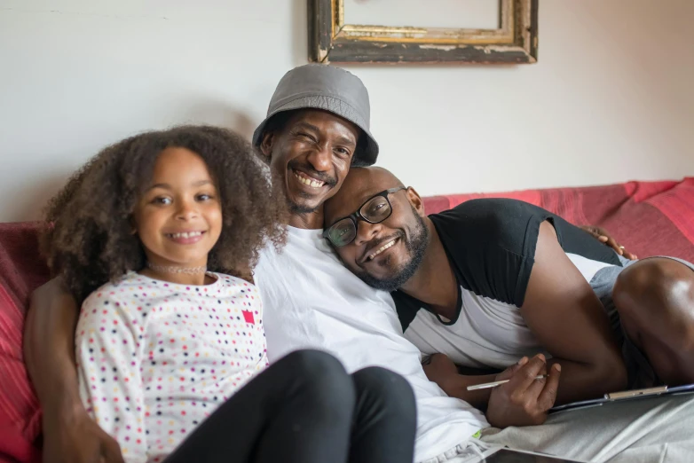 a couple of people that are sitting on a couch, a portrait, pexels contest winner, father with child, african canadian, avatar image, portrait of family of three