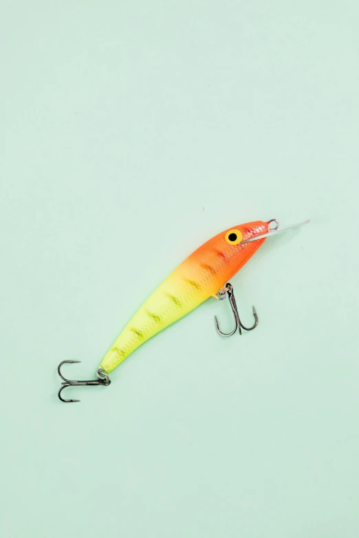 a close up of a lure on a white surface, a digital rendering, trending on pexels, gradient yellow to red, white neon wash, mastercraft, in plastic