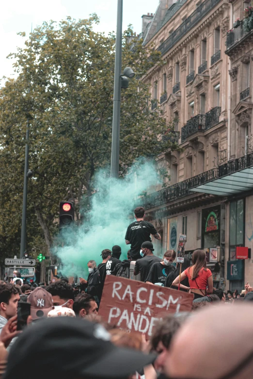 a group of people that are standing in the street, green smoke, in paris, trans rights, race