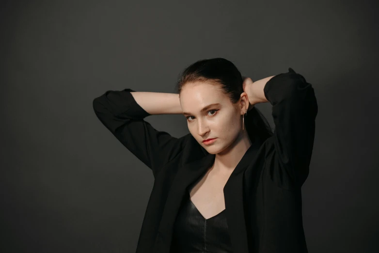 a woman in a black jacket posing for a picture, pexels contest winner, slicked-back hair, elongated arms, high forehead, moleksandra shchaslyva