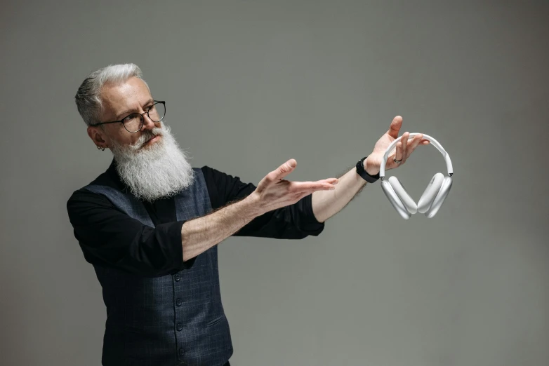 a man with a white beard holding a pair of headphones, kinetic art, futuristic product design, glass sculpture of a heart, pitch bending, tech demo