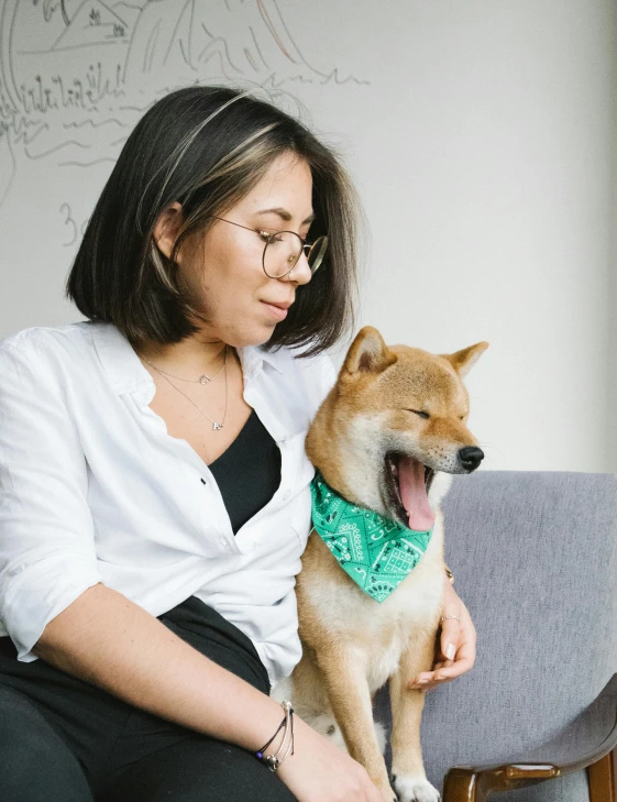 a woman sitting on a couch with a dog, inspired by Shiba Kōkan, trending on unsplash, shin hanga, bandana, wearing green, profile image, proud looking