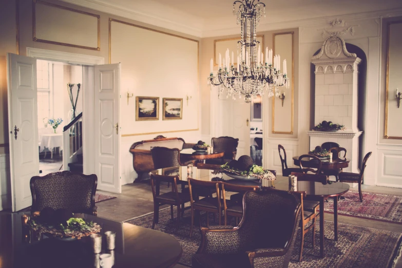 a living room filled with furniture and a chandelier, by Jesper Knudsen, unsplash, art nouveau, gourmet restaurant, nostalgic atmosphere, gentleman, journalism photo