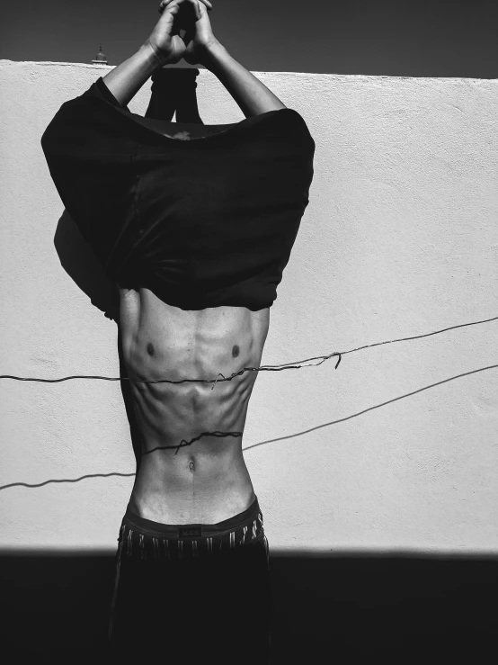 a black and white photo of a man with his back to the camera, a black and white photo, by Silvia Pelissero, pexels contest winner, hyperrealism, cables on her body, physical : tinyest midriff ever, androgyny, shot with iphone 1 0