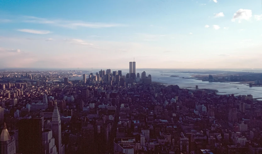 a view of a city from the top of a building, world trade center twin towers, unsplash photography, 90's photo, summer evening