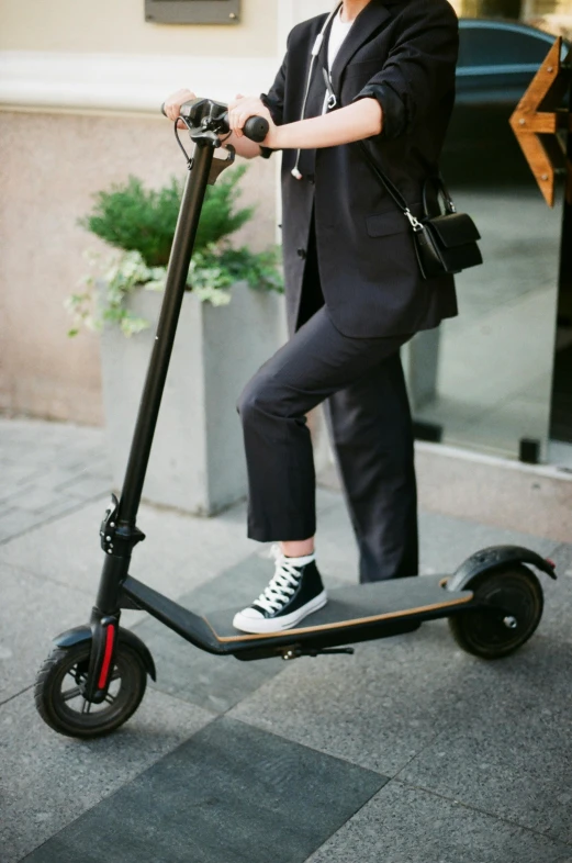 a woman riding a scooter on a city street, trending on pexels, a man wearing a black jacket, pants, slate, electric