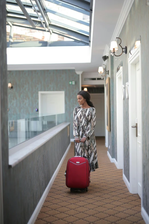 a woman walking down a hallway with a red suitcase, balcony, african ameera al taweel, superior, 8 l