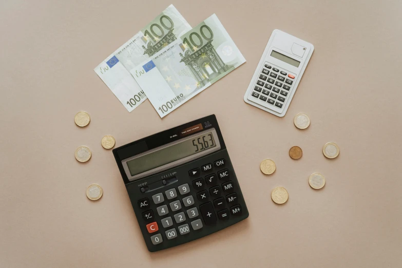 a calculator sitting on top of a table next to money, a photo, by Matija Jama, pexels, dau-al-set, knolling, brown scales, van lieven, circle