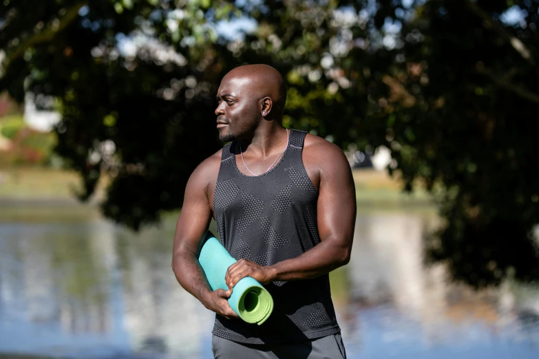 a man holding a water bottle and a yoga mat, by Julian Allen, hurufiyya, portrait image, lance reddick, profile image, parks